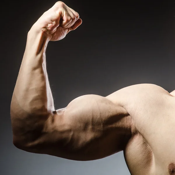 Hombre musculoso posando en estudio oscuro — Foto de Stock