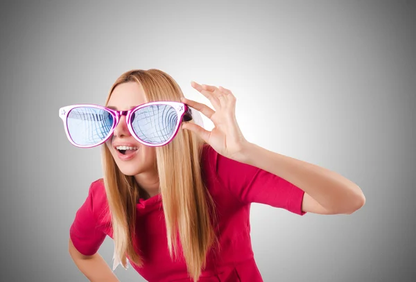Tall model with giant sunglasses against the gradient