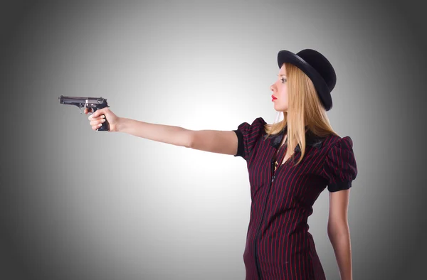 Vrouw met een pistool tegen het verloop — Stockfoto
