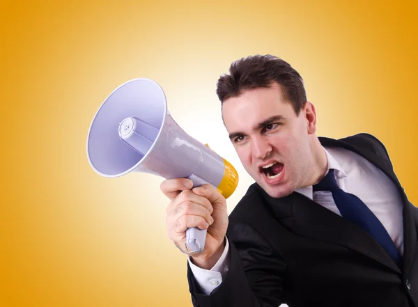 Young businessman with loudspeaker against the gradient — Stock Photo, Image