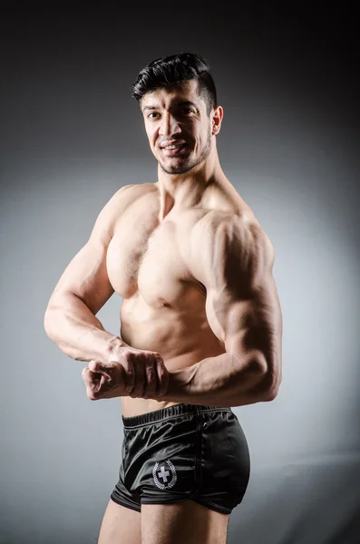 Muskulös man poserar på grå bakgrund — Stockfoto