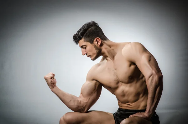 Gespierde man, die zich voordeed op grijze achtergrond — Stockfoto