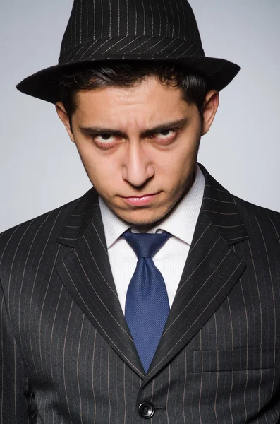 Hombre joven en traje de rayas clásicas y sombrero aislado en gris — Foto de Stock