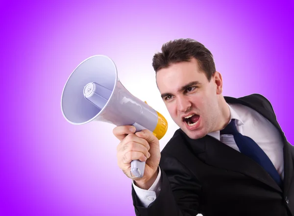 Young businessman with loudspeaker against the gradient — Stock Photo, Image