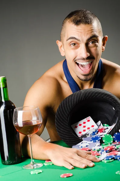 Человек пьет и играет в казино — стоковое фото