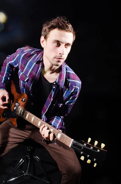 Homme jouant de la guitare dans la chambre noire — Photo