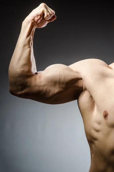 Hombre musculoso posando en estudio oscuro — Foto de Stock