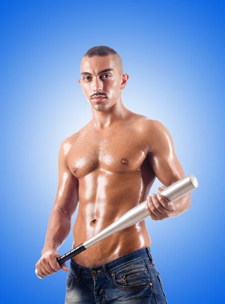 Muscular man with baseball bat against gradient — Stock Photo, Image