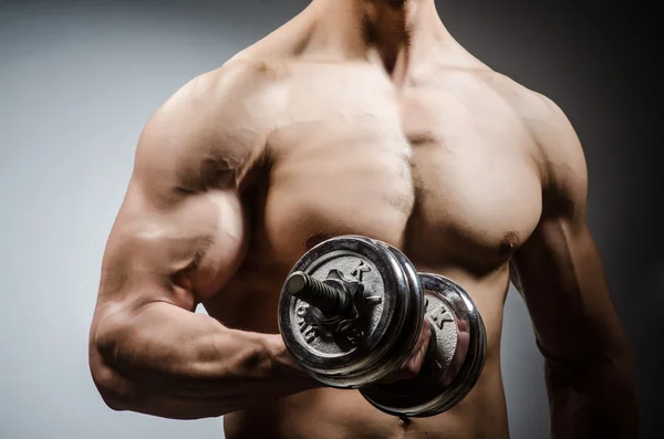 Muscular geript bodybuilder met halters op grijze achtergrond — Stockfoto