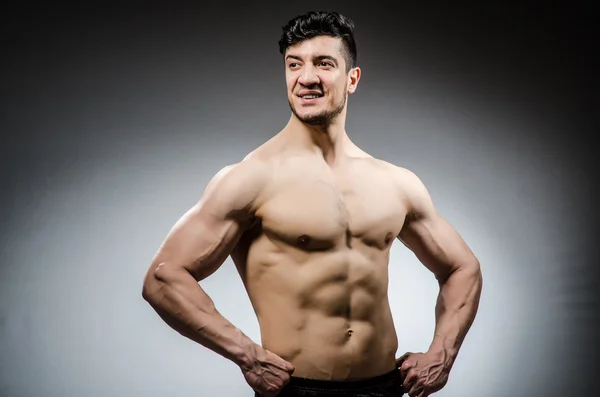 Muscle slet bodybuilder på grå bakgrund — Stockfoto
