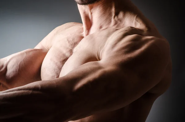 Homem muscular posando em fundo cinza — Fotografia de Stock