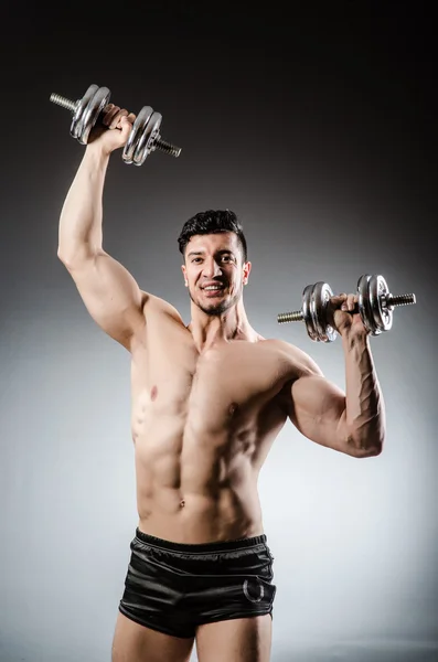 Uomo muscolare in posa su sfondo grigio — Foto Stock