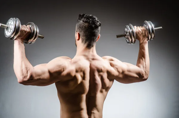 Homem muscular posando em fundo cinza — Fotografia de Stock