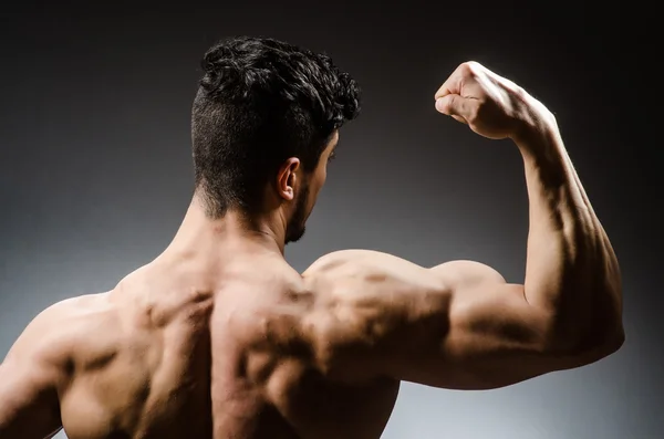 Hombre musculoso posando sobre fondo gris — Foto de Stock