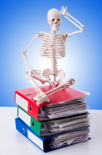 Esqueleto com pilha de arquivos contra gradiente — Fotografia de Stock