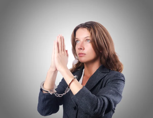 Female businesswoman with handcuffs against gradient — Stock Photo, Image