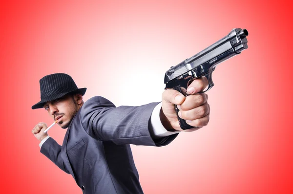 Businessman with gun against the gradient — Stock Photo, Image