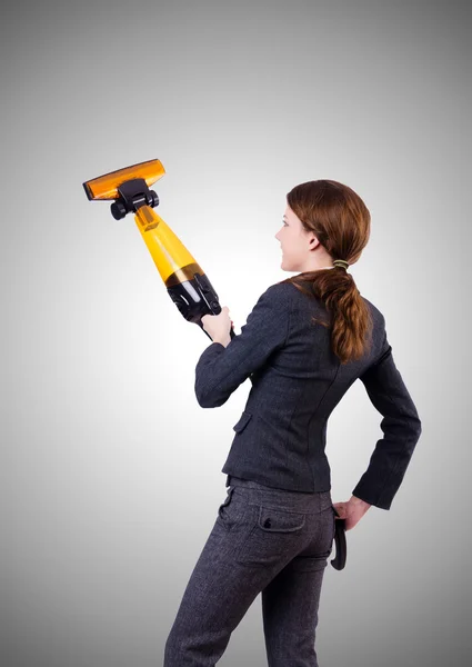 Young woman with vacuum cleaner against gradient — Stock Photo, Image