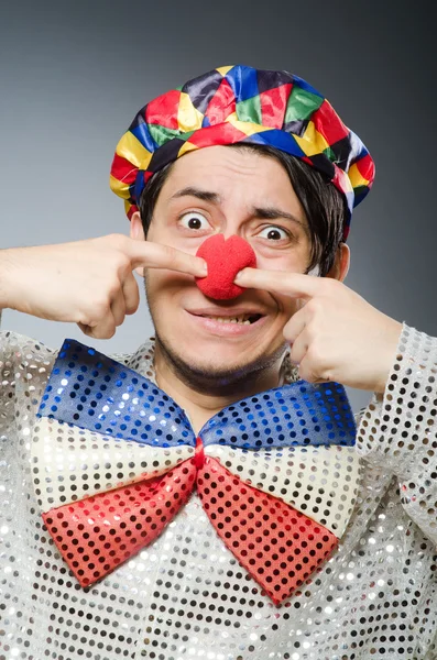 Grappige clown tegen de grijze achtergrond — Stockfoto