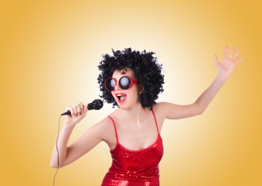 Degrade karşı Kırmızı elbiseli mikrofon ile pop yıldızı 