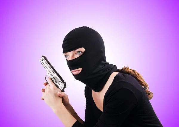 Žena v kuklu s pistolí — Stock fotografie
