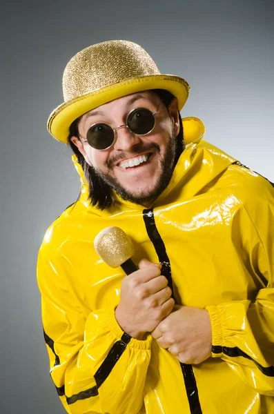 Hombre vestido de traje amarillo con micrófono — Foto de Stock