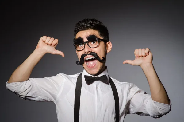 Jongeman met valse snor geïsoleerd op grijs — Stockfoto