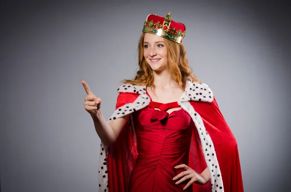 Menina bonita em vestido vermelho com arma isolada em cinza — Fotografia de Stock