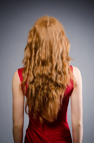 Menina bonita em vestido vermelho com arma isolada em cinza — Fotografia de Stock