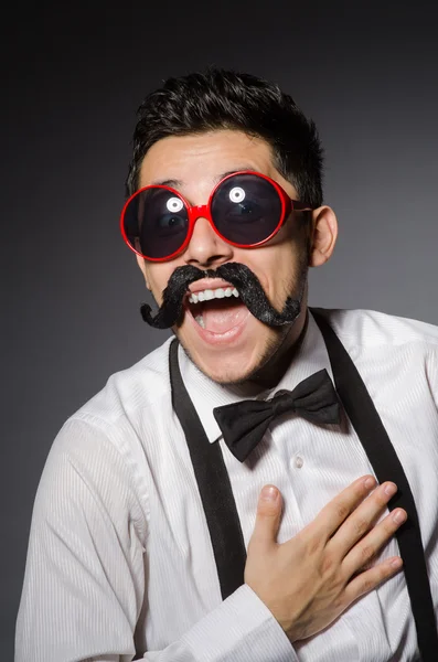 Jeune homme avec fausse moustache isolé sur gris — Photo