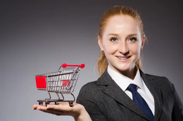 Geschäftsfrau mit Einkaufswagen isoliert auf grau — Stockfoto