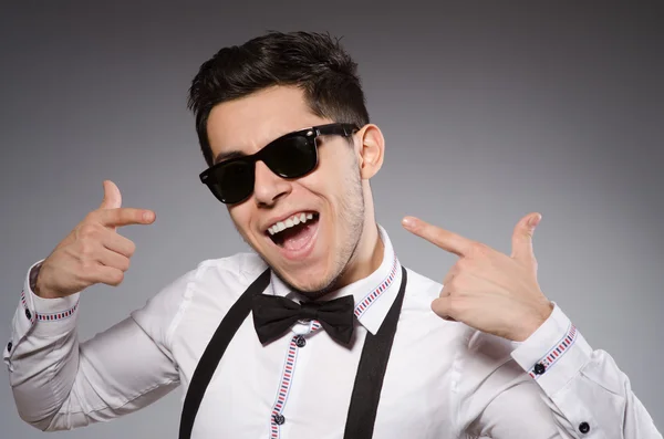 Joven hombre elegante con gafas de sol aislado en gris —  Fotos de Stock