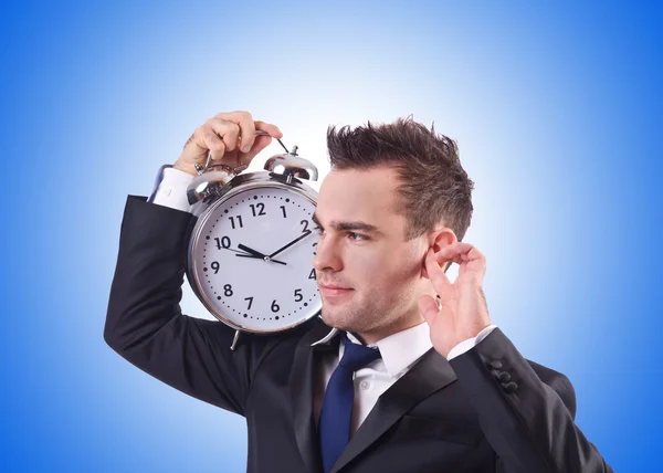 Homme d'affaires avec horloge contre le gradient Photo De Stock