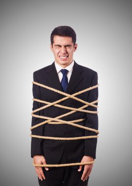 Businessman tied up with rope against gradient  clipart