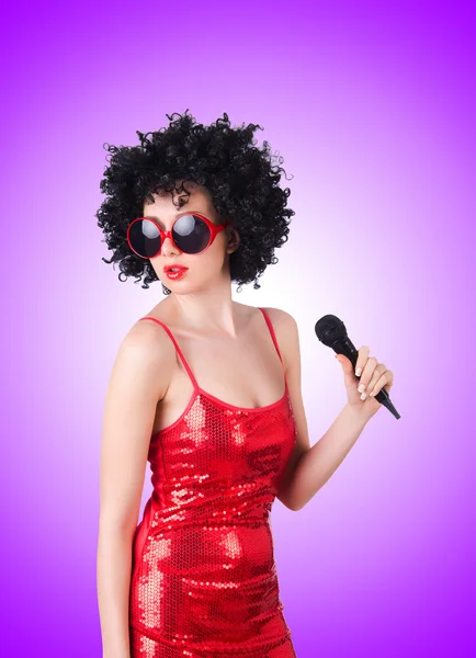 Pop star with mic in red dress against the gradient — Stock Photo, Image