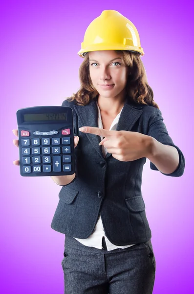 Female builder with calculator against the gradient — Stock Photo, Image