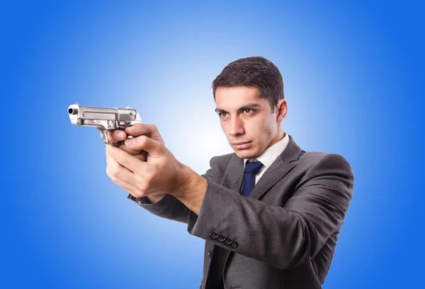 Homme d'affaires avec arme contre le gradient — Photo