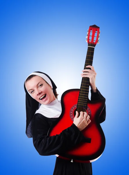 Monja tocando la guitarra contra el gradiente — Foto de Stock