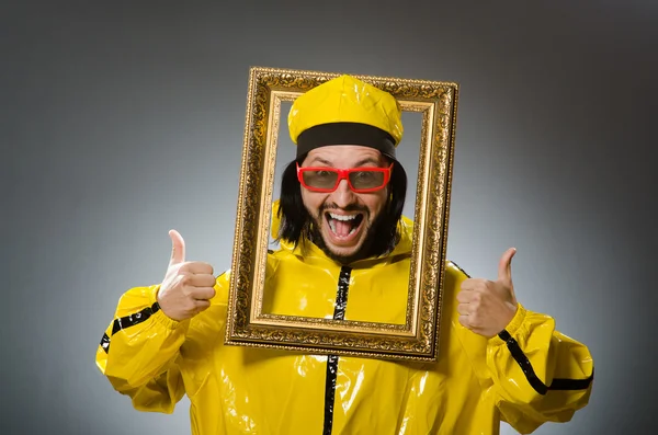 Man met gele pak met fotolijst — Stockfoto