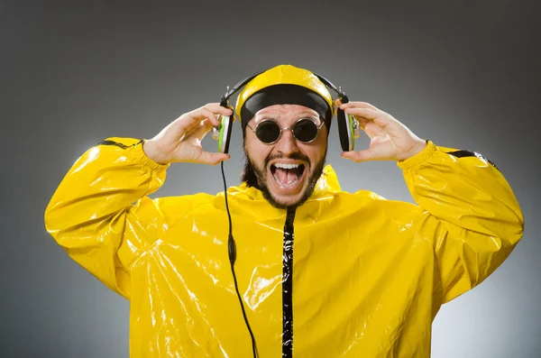 Άνθρωπος που φοράει κίτρινο κοστούμι ακούγοντας ακουστικά — Φωτογραφία Αρχείου