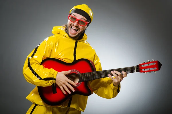 Αστείος άνθρωπος φοράει κίτρινο κοστούμι και να παίζει κιθάρα — Φωτογραφία Αρχείου