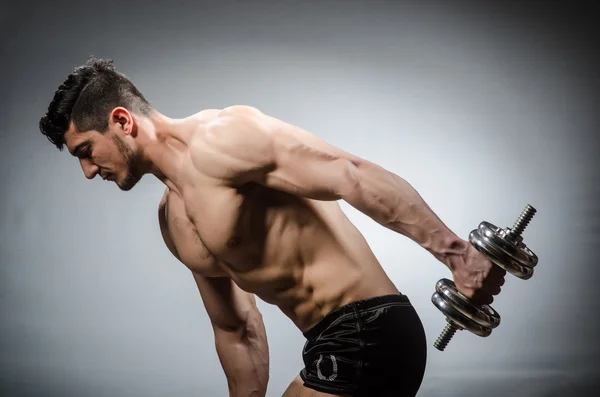 Muscular fisiculturista rasgado com halteres — Fotografia de Stock