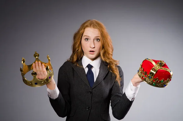 Woman with crowns against grey background — Stock Photo, Image