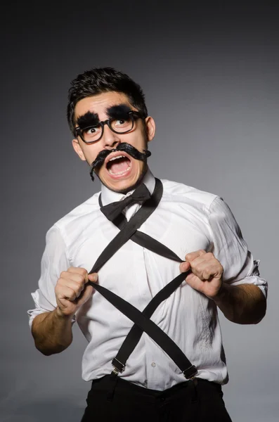 Young man with false moustache isolated on gray — Stock Photo, Image