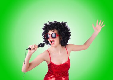 Degrade karşı Kırmızı elbiseli mikrofon ile pop yıldızı 