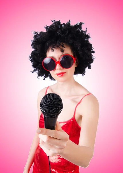 Estrella pop con micrófono en vestido rojo contra gradiente —  Fotos de Stock