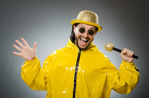 Homem usando terno amarelo com microfone — Fotografia de Stock