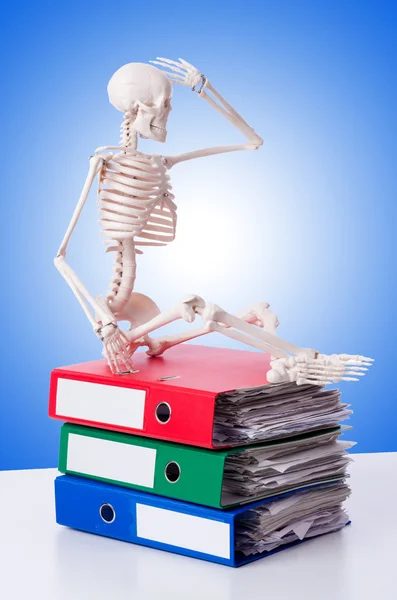 Skeleton with pile of files against gradient — Stock Photo, Image