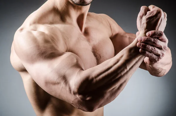 Homem muscular posando em estúdio escuro — Fotografia de Stock