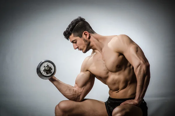 Muscular fisiculturista rasgado com halteres — Fotografia de Stock